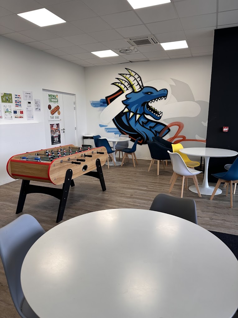 Salle de repos des élèves de Groupe Alternance Metz : il y a un baby-foot, des tables et des chaises. On peut voir un beau graffiti sur le mur représentant un dragon, ce qui fait référence au Graoully de Metz.