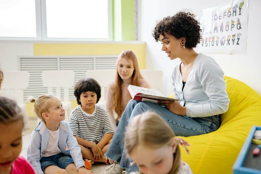 Animatrice lisant une histoire à un groupe d'enfants dans une salle de loisirs
