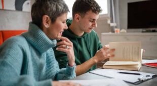 Un étudiant adolescent caucasien étudie avec l’aide de son tuteur, professeur ou de sa mère, une femme âgée, à la maison, lors d’une leçon particulière pour préparer un examen. Concept d’éducation, personnes réelles
