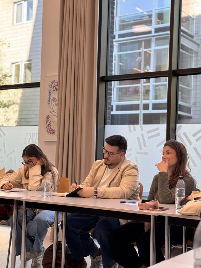 trois étudiants en MBA MDO qui écoutent une présentation au danemark
